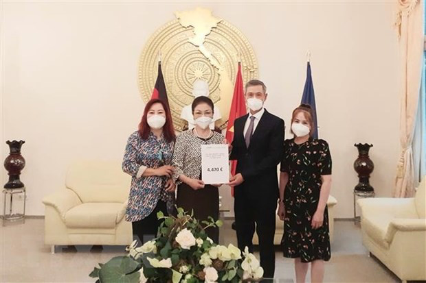 Ambassador Nguyen Minh Vu received the money from the Hai Phong People's Association in Germany to support the prevention and control of the Covid-19 epidemic in Vietnam. (Source: VNA)