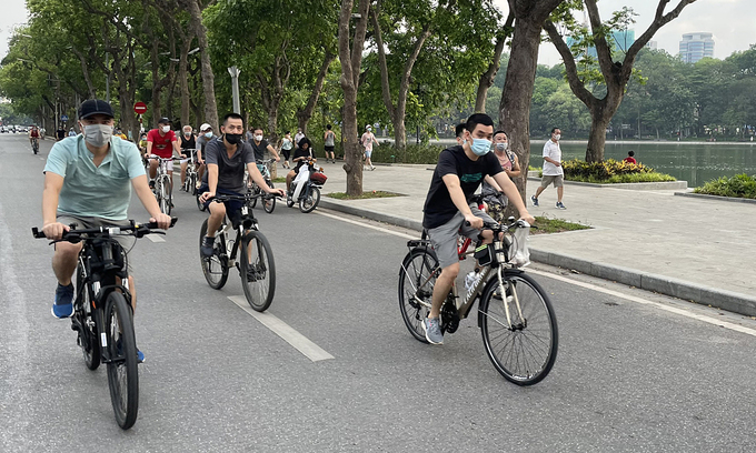People ride bikes around Hanoi's iconic Hoan Kiem Lake in Hoan Kiem District. Photo: VnExpress