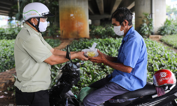 A motorbike taxi driver receives a charity meal in HCMC, July 2021. Photo: VnExpress