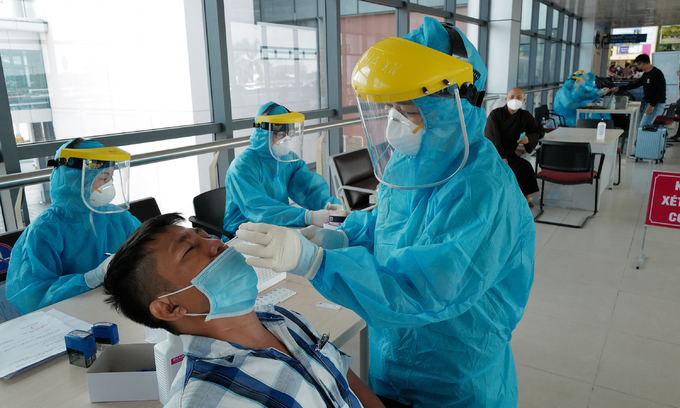 A medical staff takes a sample of a passenger for Covid-19 testing at Noi Bai International Airport on July 15, 2021. Photo: VnExpress