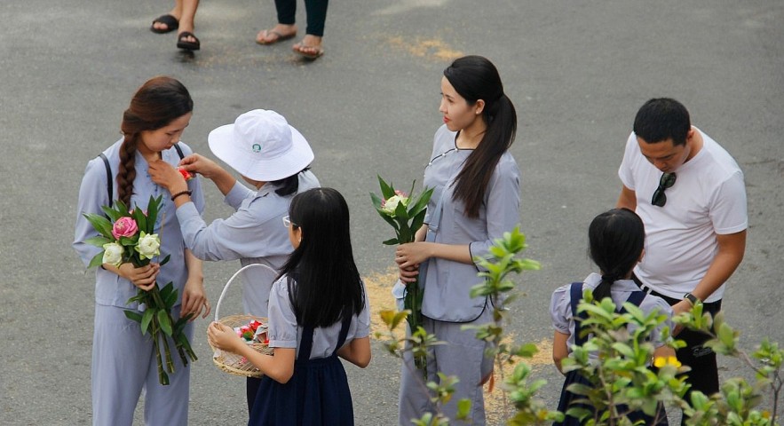 Worshipers at Phổ Quang Temple in Saigon are given either a red of white rose before joining festivities. The red one is for those who have a mother, and the white one is for those without. Photo: saigoneer