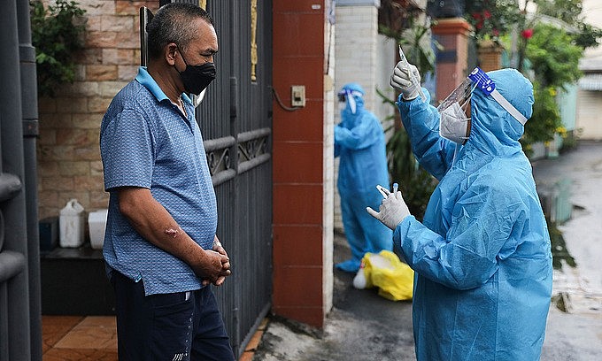 A health worker instructs a man on how to take a quick Covid-19 test in Binh Thanh District, HCMC, August 23, 2021. Photo: VnExpress