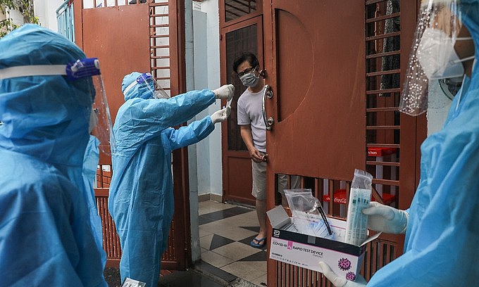 Medical staff instruct a man on Covid-19 testing in HCMC's Binh Thanh District, August 23, 2021. Photo: VnExpress