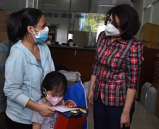 Local authorities present aid to an orphan who lost her parents to the COVID-19 pandemic in Ho Chi Minh City. Photo: VNA