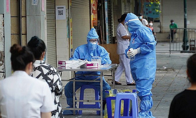 Medics prepare to take samples of people on Phu Doan Street of Hanoi's Hoan Kiem District to trace people linked to a new cluster at Viet Duc Hospital, September 30, 2021. Photo: VnExpress