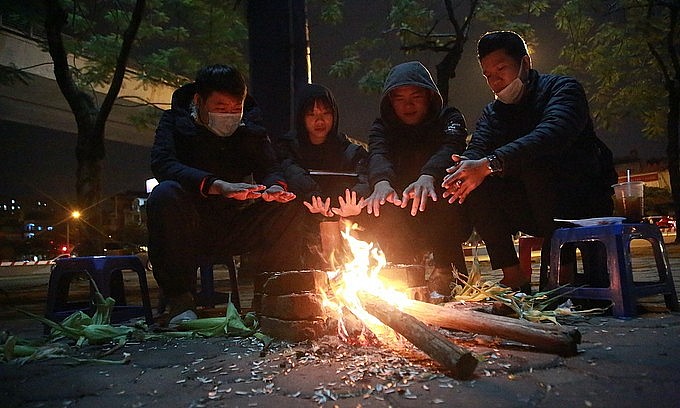 People light up a fire for warmth on January 1, 2021. Photo: VnExpress
