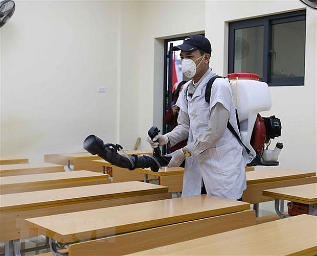 Spraying disinfectants in a classroom. Photo: VNA