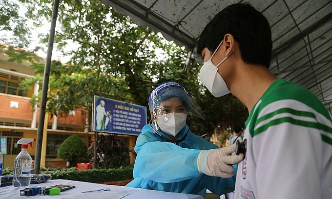 A medical staff examines a student's health before giving Covid-19 vaccine in Ho Chi Minh City, Oct. 27, 2021. Photo: VnExpress