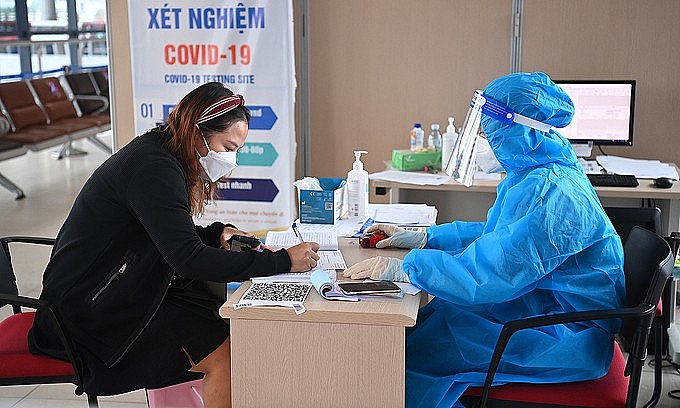 A woman fills in a form to be tested for the novel coronavirus at Noi Bai Airport in Hanoi, October 2021. Photo: VnExpress