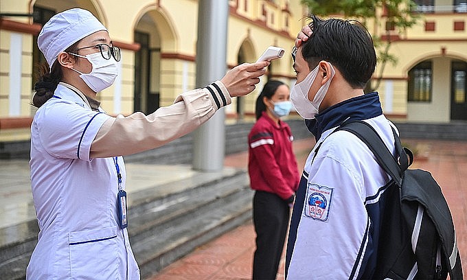 A medic checks the body temperature of a student at Tay Dang Middle School in Hanoi's Ba Vi District, Nov. 8, 2021. Photo: VnExpress