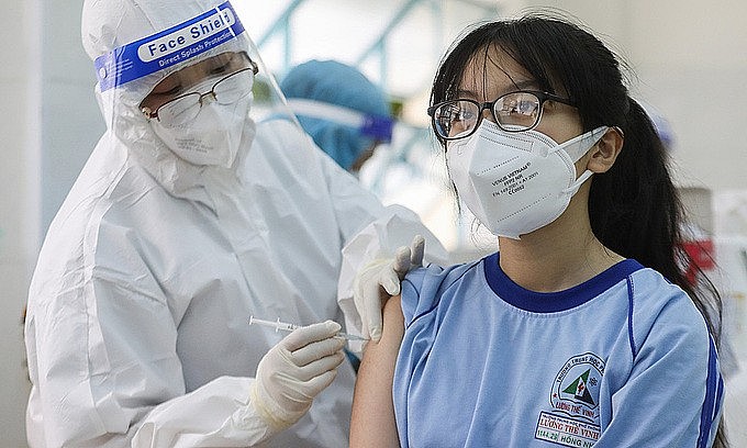 A medic inoculates Covid-19 vaccine to a high school girl in District 1, HCMC, Oct. 27, 2021. Photo: VnExpress