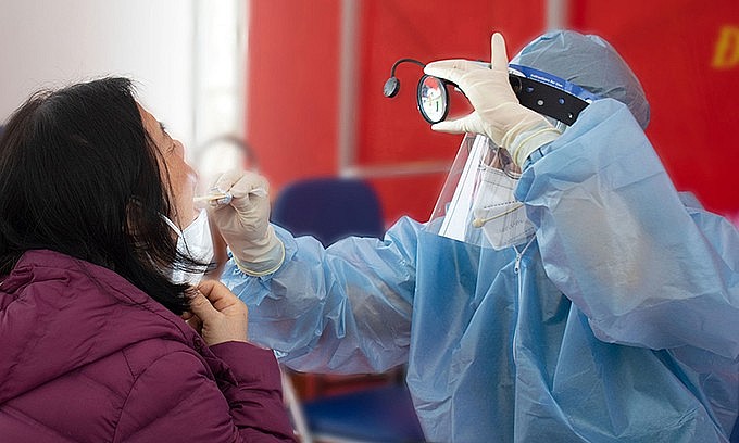 A medical worker checks a Covid-19 patient in Dong Da District of Hanoi, November 20, 2021. Photo: VnExpress