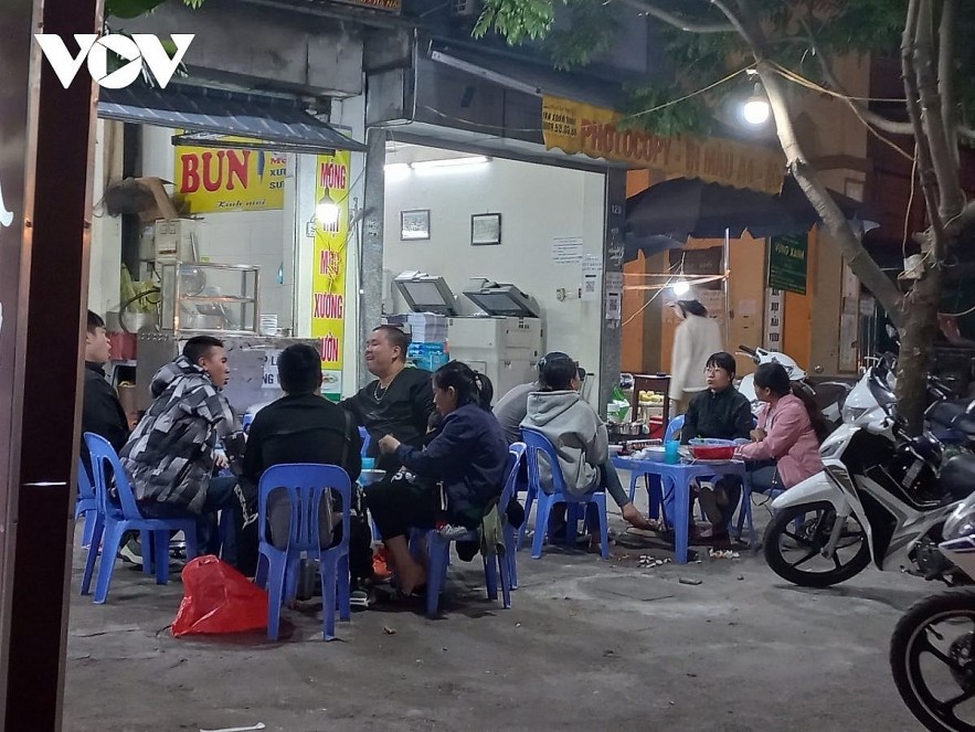 Large gatherings of people sit at sidewalk cafes in Hanoi chatting without wearing masks and maintaining a safe distance. Photo: VOV