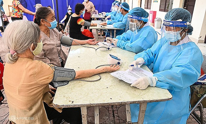 Two elderly women have their blood pressure checked before vaccination at a Covid-19 testing site in Hanoi's Ba Dinh District, September 10, 2021. Photo: VnExpress
