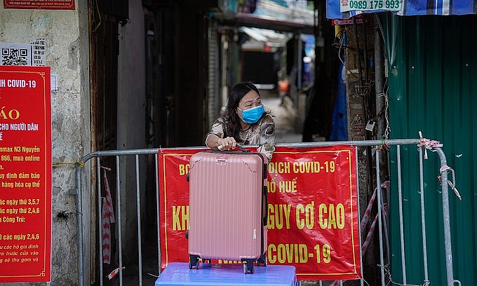A woman in an isolated area on Nguyen Cong Tru Street in Hanoi's Hai Ba Trung District receives goods delivered to her by relatives, December 1, 2021. Photo: VnExpress