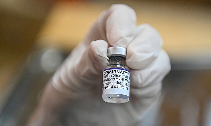 A medical staff holds a bottle of Covid-19 vaccine in Hanoi, November 2021. Photo: VnExpress