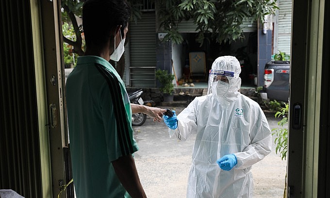 A health worker comes to a house in HCMC's Thu Duc City to deliver drugs to a Covid-19 patient, September 3, 2021. Photo: VnExpress