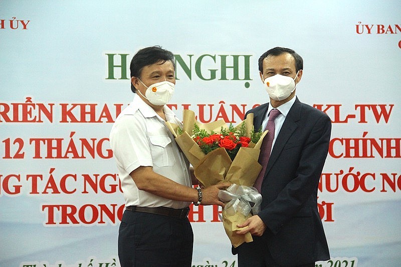 Phung Cong Dung, chairman of the Ho Chi Minh City Committee for Overseas Vietnamese Affairs, presents flowers to Luong Thanh Nghi, vice chairman of the State Committee for Overseas Vietnamese Affairs. Photo: Le Thoa