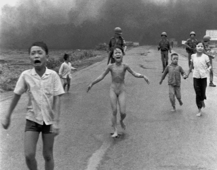 Kim Phuc, center, with her clothes torn off, flees with other South Vietnamese children after a misdirected American aerial napalm attack on June 8, 1972.
