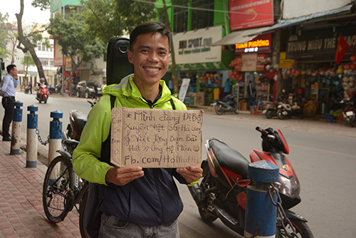 Ho Nhat Ha with a sign that says: Im walking across Vietnam. Would be happy to write you a song. Please support me! Photo provided by Ho Nhat Ha.